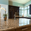 close up of new kitchen marble island with painted cabinets in background