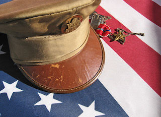 heroes_day Military cap atop American flag