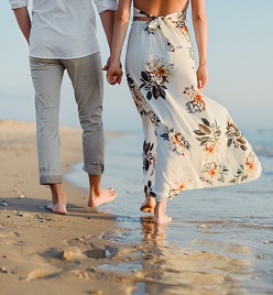 Bride and groom on beach holding hands