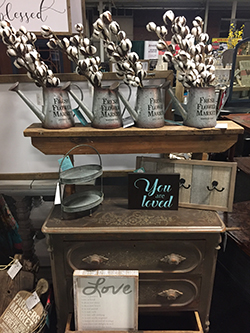 ArtisanMarket-small Flowers in metal watering cans with home decor products on display