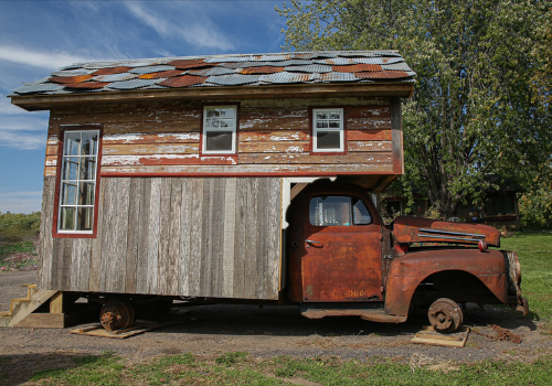 Custom shed made out of old red truck and aged barn house wood