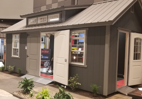 Charcoal grey pro shed model white barn doors open on trade show floor