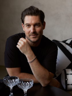 Craig Conover portrait with two coupe champagne glasses